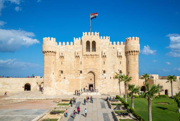 Qaitbay Citadel in Alexandria, Egypt, with visitors exploring the historic medieval fortress.