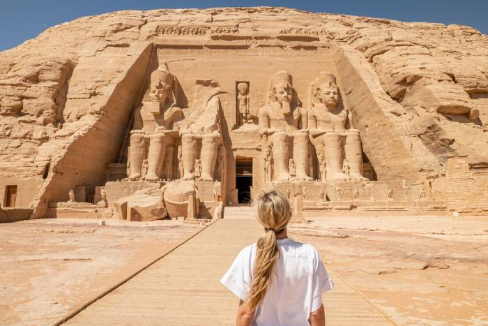 Traveler admiring the magnificent Abu Simbel Temple, one of Egypt's most iconic ancient monuments.