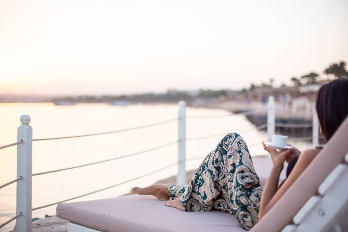 Traveler relaxing by the Nile River at sunset while enjoying a peaceful cruise in Egypt.