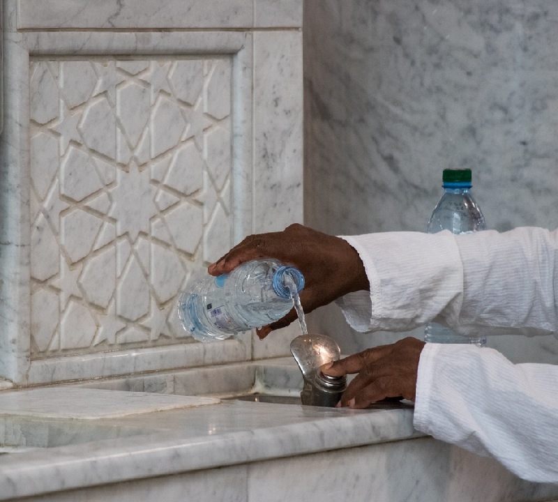 Filling Zamzam water into the bottle. Filling Zamzam water into the bottle.