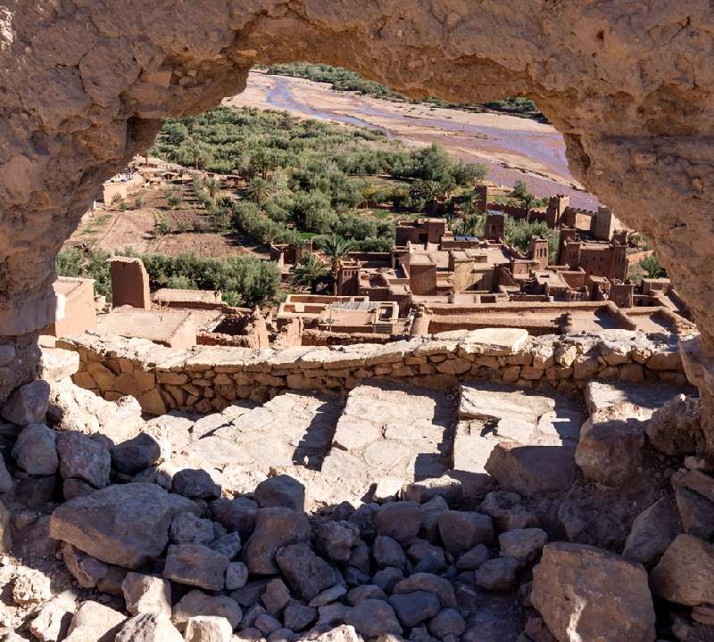 Vista da casbá através de um buraco em Ait Benhaddou, em Ouarzazate, Marrocos. Ait Benhaddou é uma pequena vila localizada no Vale de Ounila, no sul de Marrocos, Patrimônio Mundial da UNESCO. Vista da casbá através de um buraco em Ait Benhaddou, em Ouarzazate, Marrocos. Ait Benhaddou é uma pequena vila localizada no Vale de Ounila, no sul de Marrocos, Patrimônio Mundial da UNESCO.